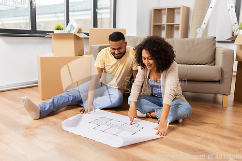 Image of couple with boxes and blueprint moving to new home