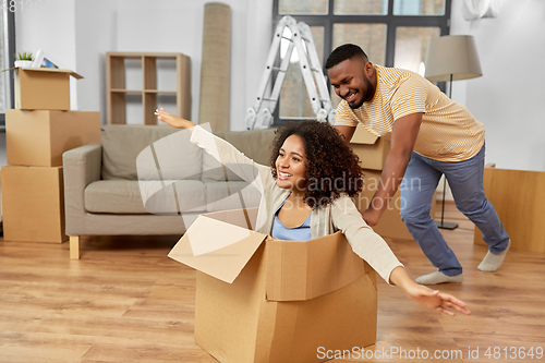 Image of happy couple moving to new home and having fun