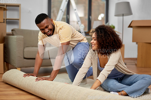 Image of happy couple with carpet moving to new home