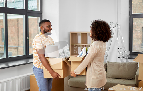 Image of happy couple with boxes moving to new home