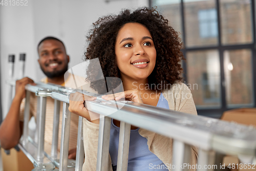 Image of happy couple with ladder moving to new home