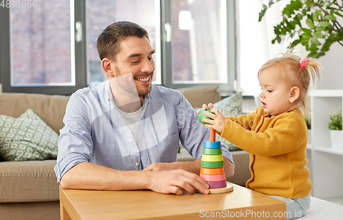 Image of father playing with little baby daughter at home