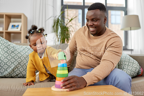 Image of african family playing with baby daughter at home