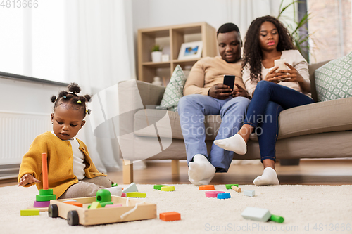 Image of african baby girl playing with toy blocks at home