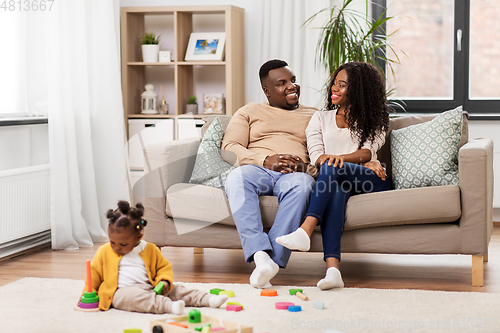 Image of african family with baby daughter playing at home