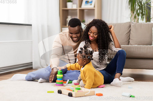 Image of african family playing with baby daughter at home