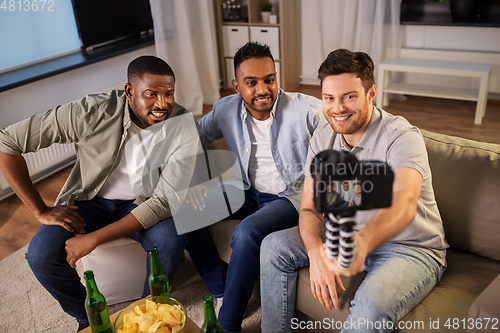 Image of male video blogger with friends and camera at home