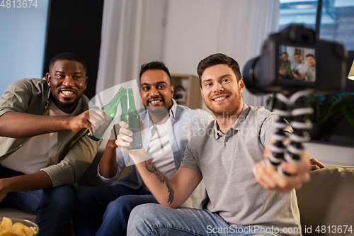 Image of male video blogger with friends and camera at home