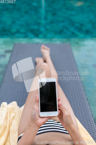 Image of Woman use of mobile phone in swimming pool