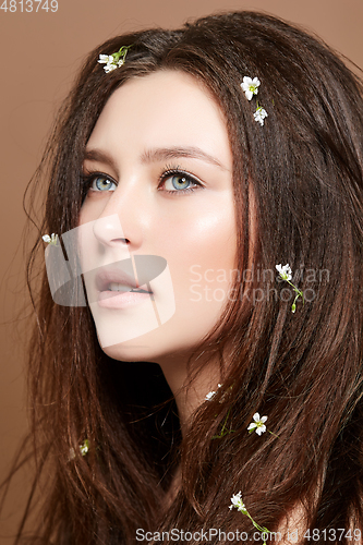 Image of girl with many small flowers in long hair
