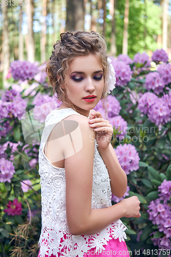 Image of girl in dress in rhododendron garden