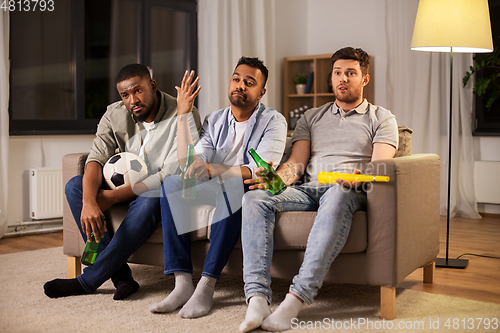 Image of sad friends with ball and vuvuzela watching soccer