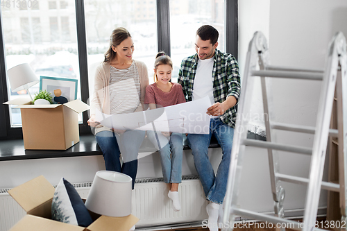 Image of happy family with blueprint moving to new home