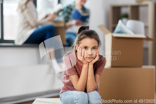 Image of sad girl moving to new home with her family