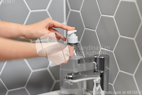 Image of close up of woman washing hands with liquid soap