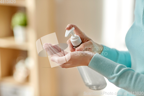 Image of close up of woman applying hand sanitizer