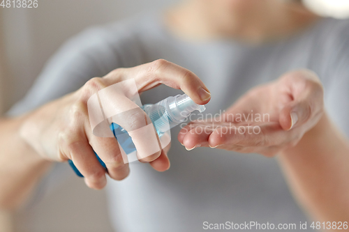 Image of close up of woman spraying hand sanitizer