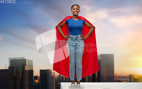 Image of happy african american woman in red superhero cape