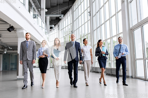 Image of business people walking along office building