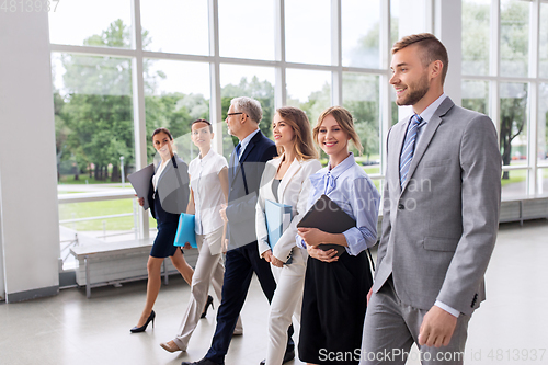 Image of business people walking along office building