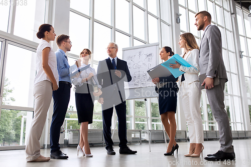 Image of business team with scheme on flip chart at office