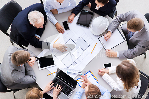 Image of architects with laptop and blueprint at office