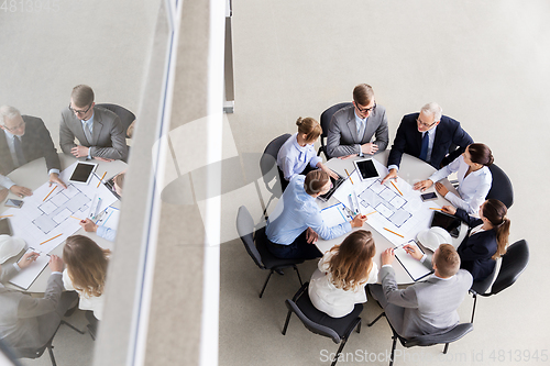 Image of architects with laptop and blueprint at office