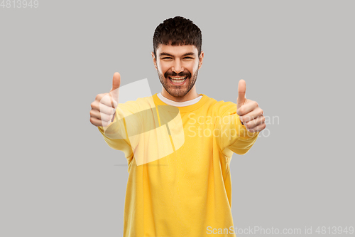 Image of smiling young man showing thumbs up