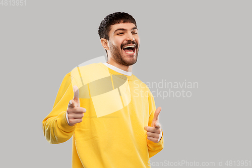 Image of smiling young man showing thumbs up