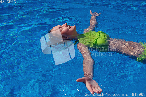 Image of teen girl relaxing near swimming pool