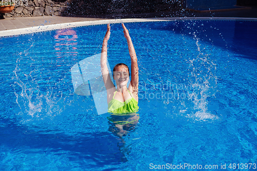 Image of teen girl relaxing near swimming pool