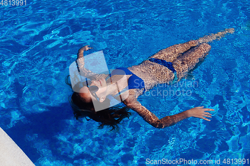Image of teen girl relaxing near swimming pool