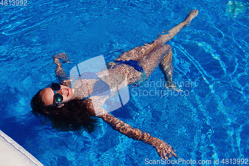 Image of teen girl relaxing near swimming pool