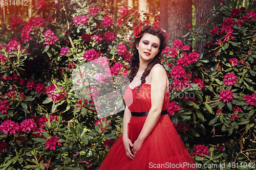 Image of girl in dress in rhododendron garden