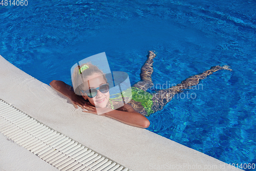 Image of teen girl relaxing near swimming pool