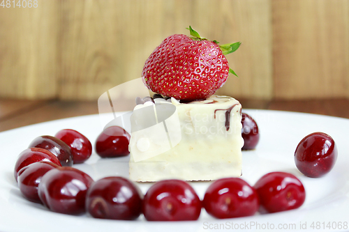 Image of ripe red strawberries and cherries with cake