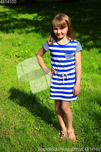 Image of little fashionable girl lies on the green grass