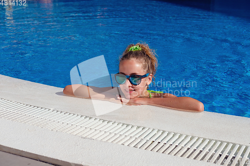 Image of teen girl relaxing near swimming pool