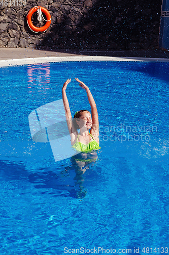 Image of teen girl relaxing near swimming pool