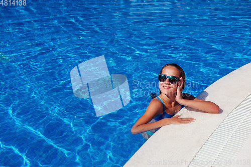 Image of teen girl relaxing near swimming pool