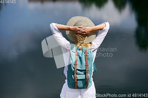 Image of Young woman resting near lake