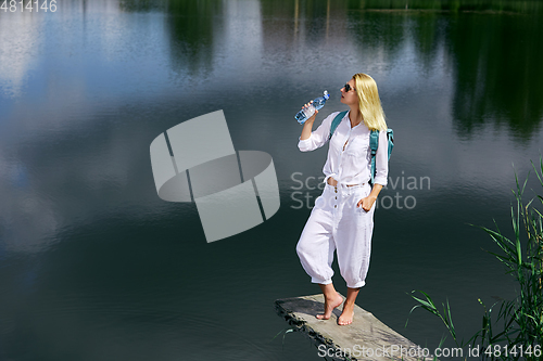 Image of Young woman resting near lake
