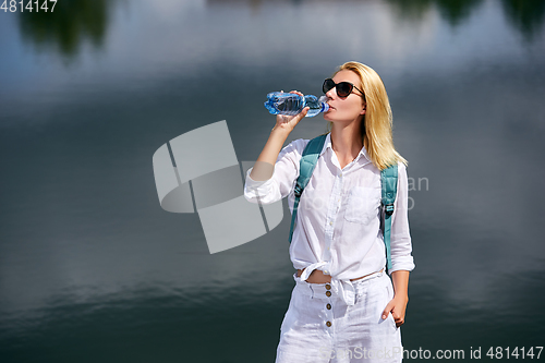 Image of Young woman resting near lake