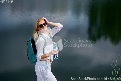 Image of Young woman resting near lake