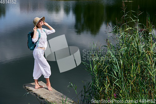 Image of Young woman resting near lake