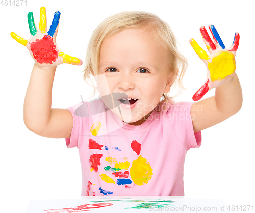 Image of Portrait of a cute little girl playing with paints