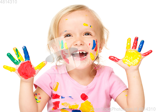 Image of Portrait of a cute little girl playing with paints