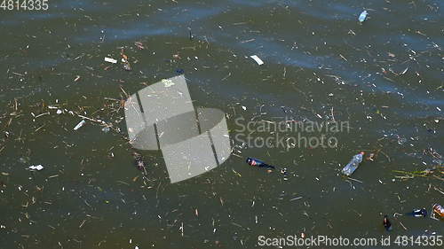 Image of Plastic bags and bottles pollution in ocean washes up onto beach.