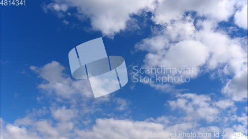 Image of Time lapse Fluffy clouds float across the blue sky.