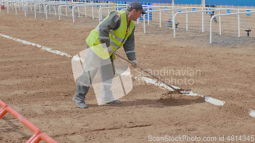 Image of The worker rakes the sand with rakes. UltraHD stock footage